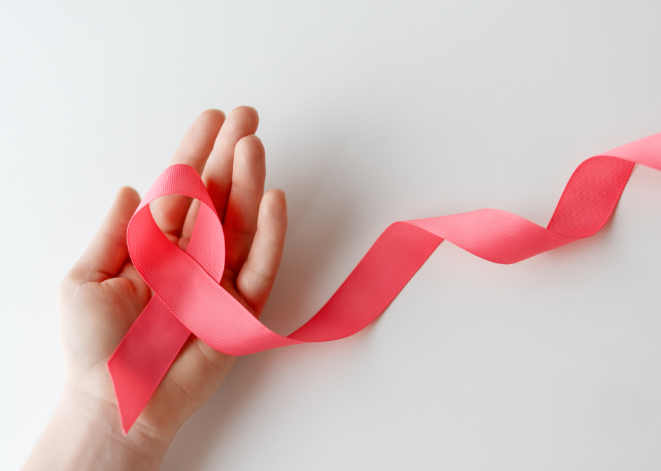 Pink ribbon in hand: Breast cancer awareness.