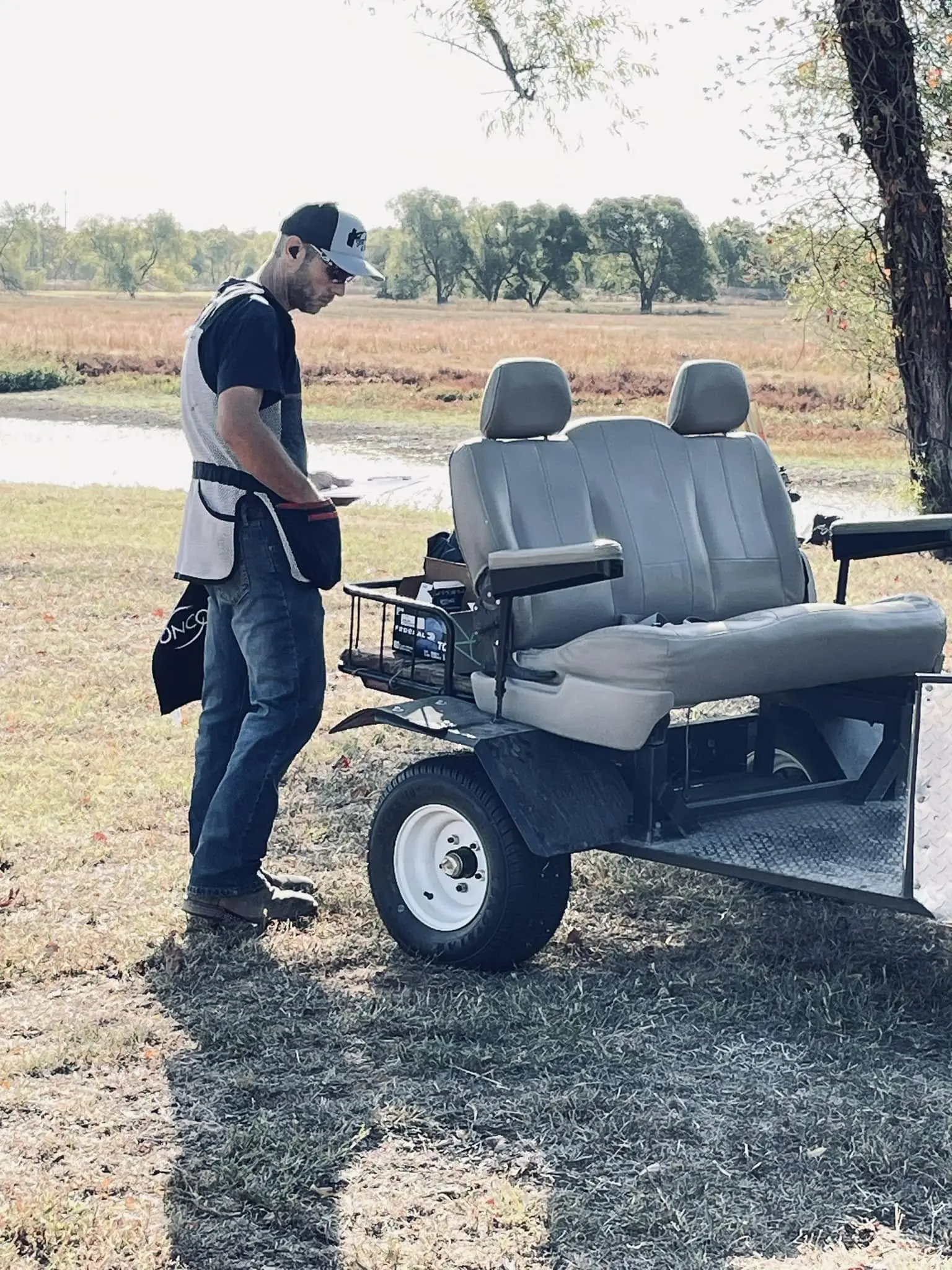 A man standing next to an electric cart.