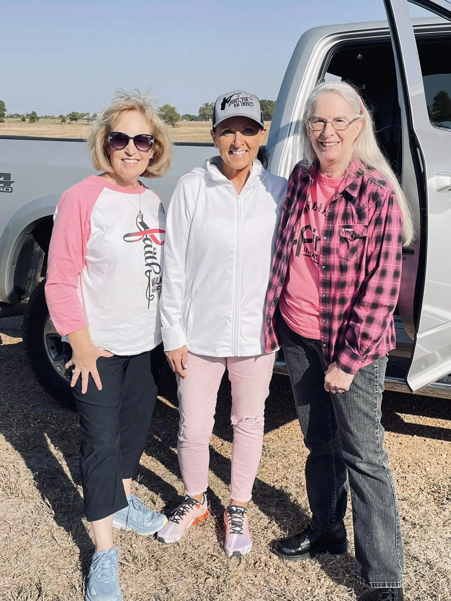 Three women standing in front of a white van.