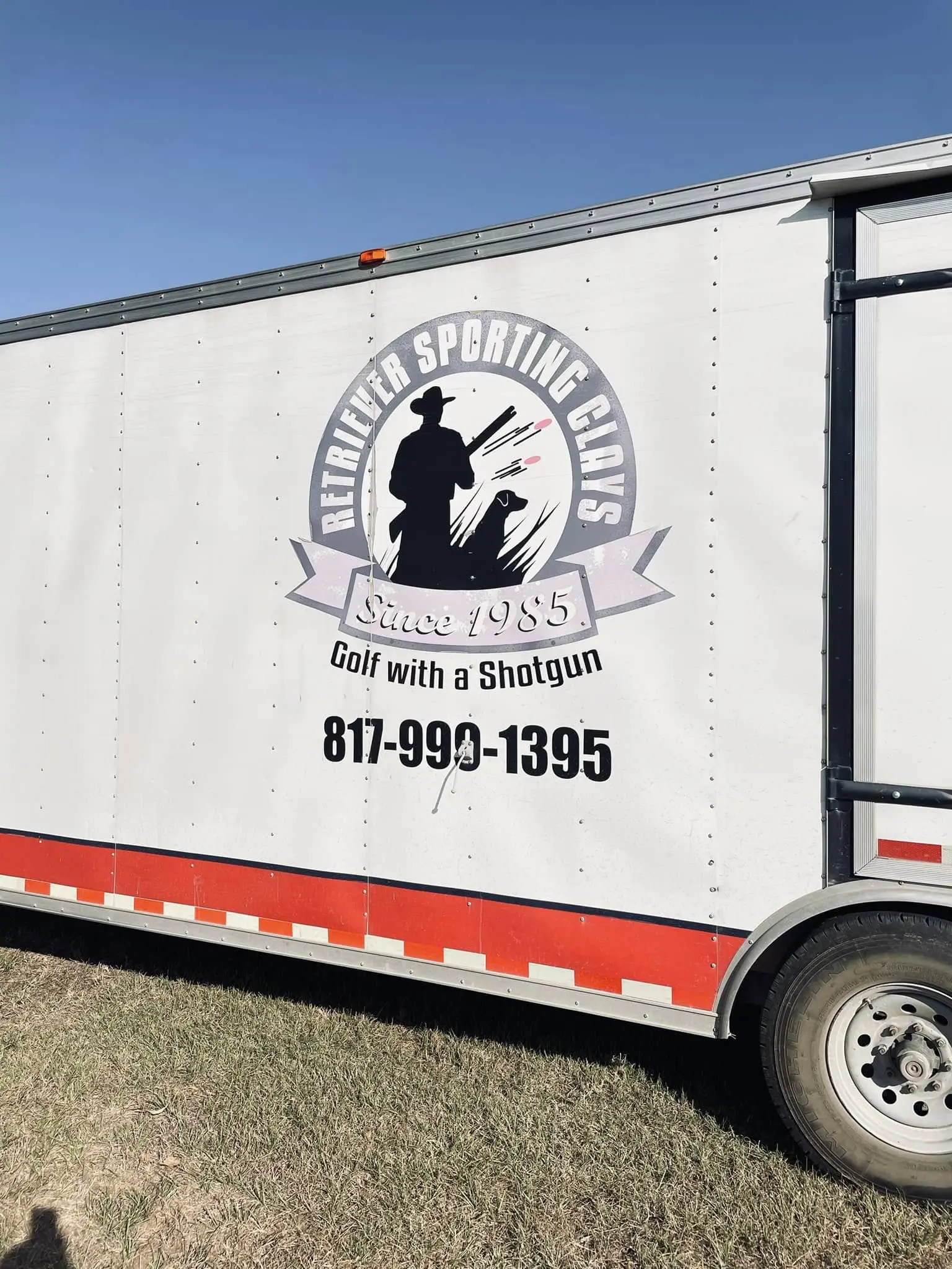 A large white trailer with the words " dedicated sporting goods golf with a shotgun ".