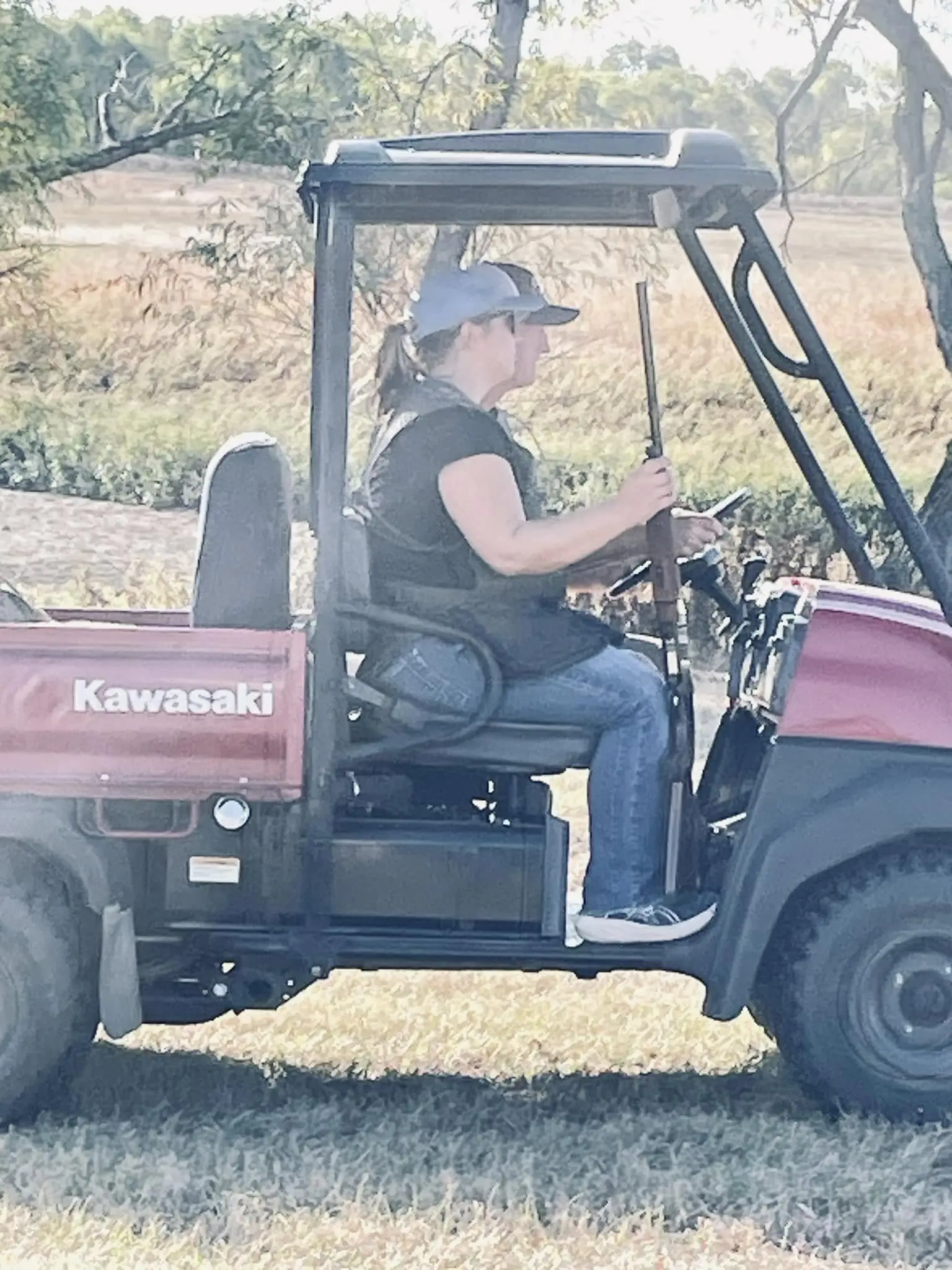 A woman riding on the back of a red utility vehicle.