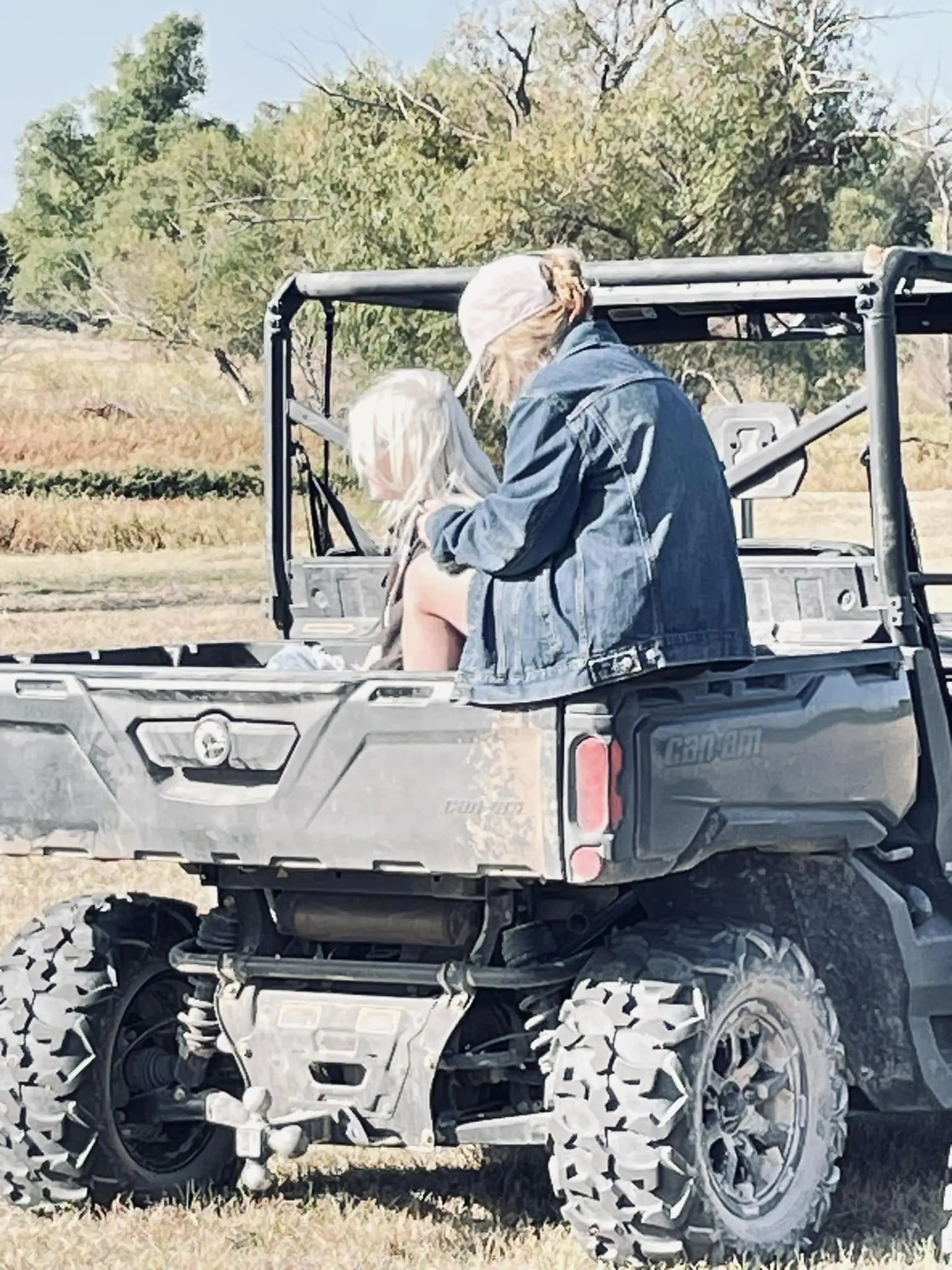 A man and child in the back of an atv.