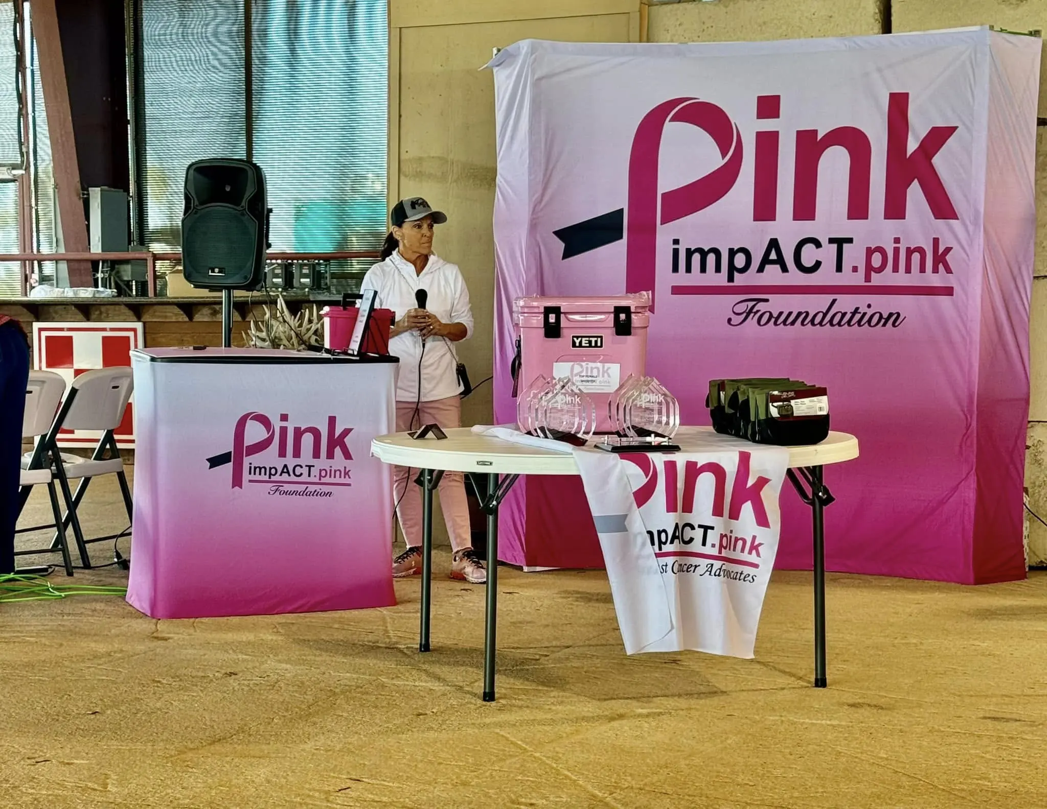 A woman standing in front of a pink sign.