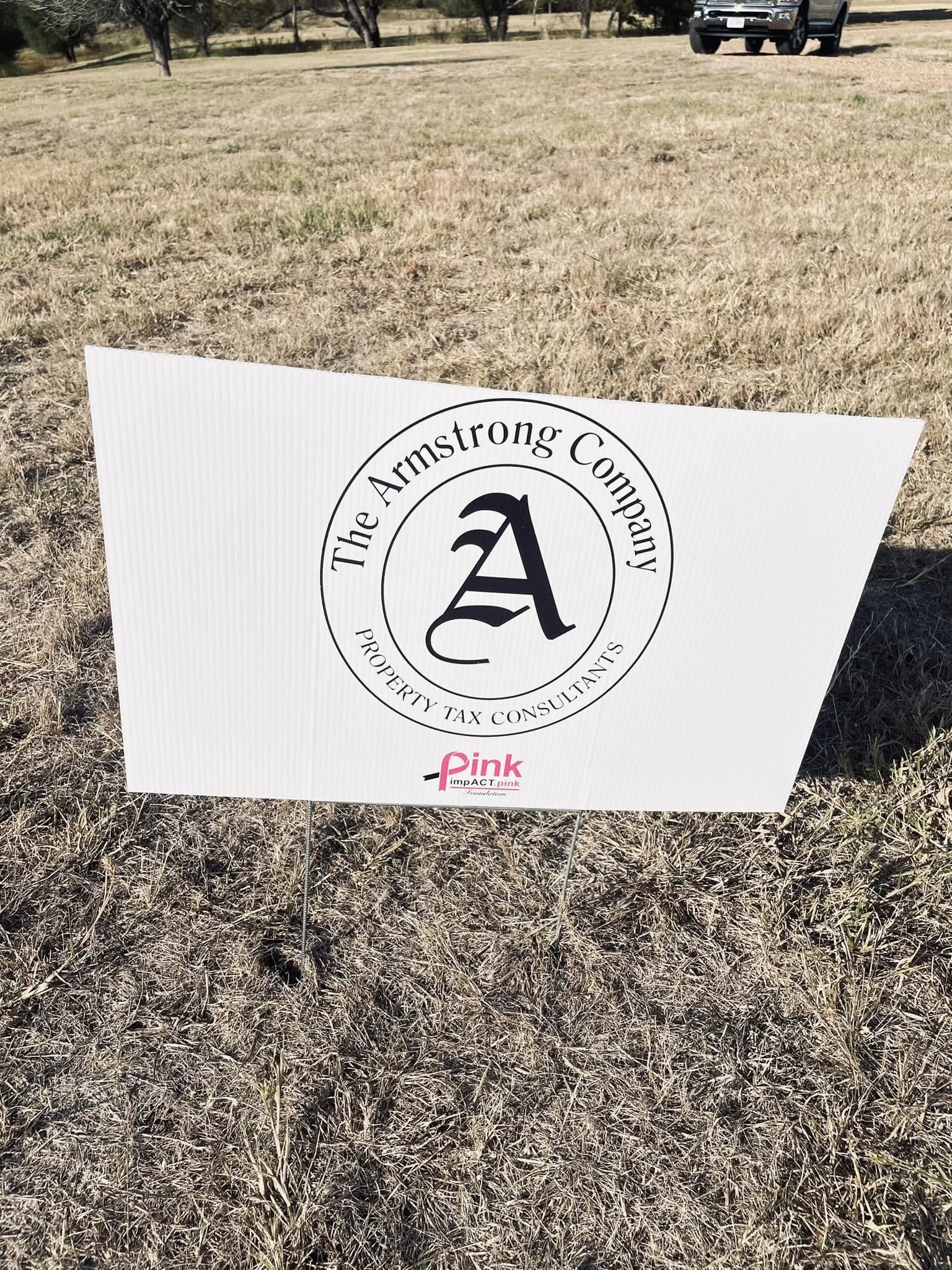 A sign sitting in the middle of a field.