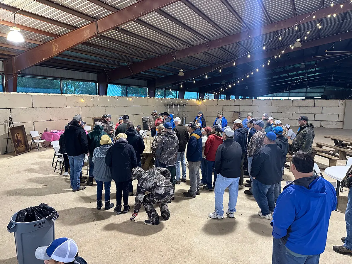 A group of people standing around in an indoor arena.